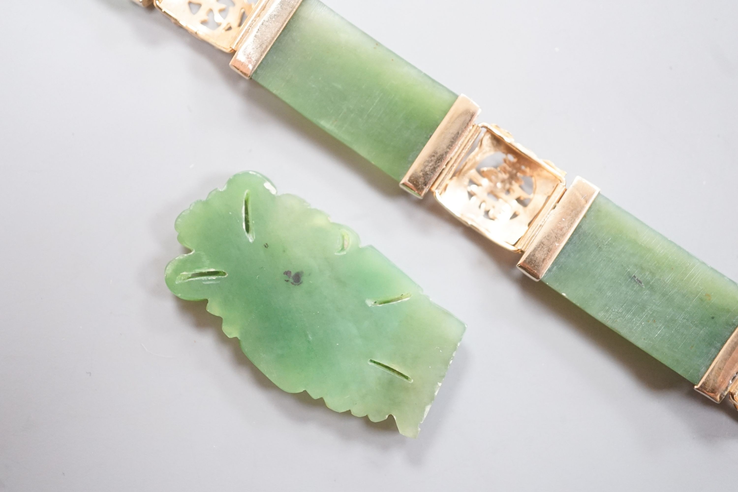 A gilt metal and jadeite mounted bracelet, 17.4cm and a carved plaque.